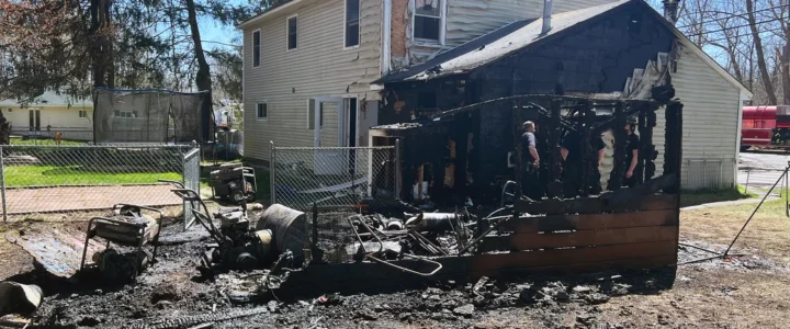Burned out shed, home with heavy fire damage to its side